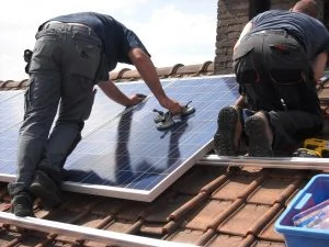 男子在家庭屋顶安装太阳能电池板