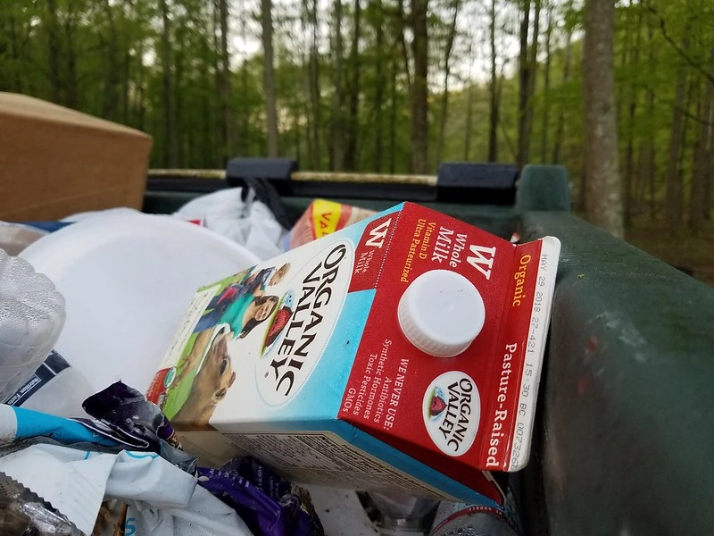 一个完整的垃圾桶，上面有牛奶纸箱